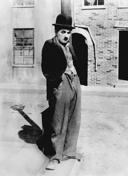 Ein Hundeleben von und mit Charlie Chaplin, stehend auf einer Straße, Hände in den Taschen. Los Ange